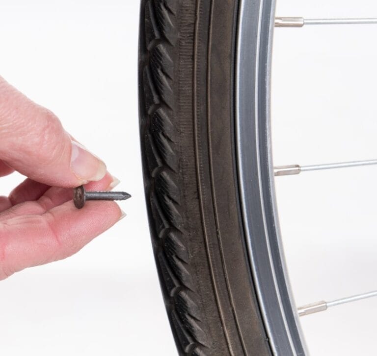 Lekke fietsband door spijker moet geplakt worden