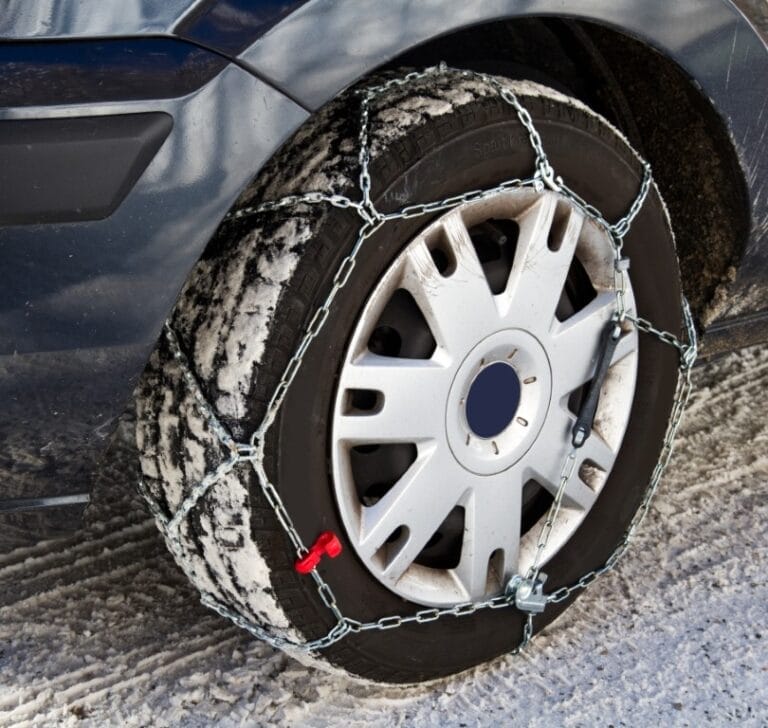 een autoband met een sneeuwketting eromheen